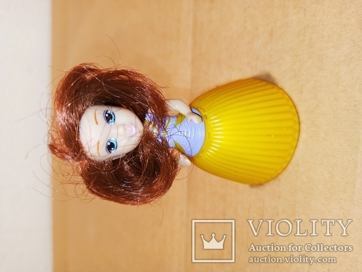 Кукла с рыжими волосами в желтой юбке.