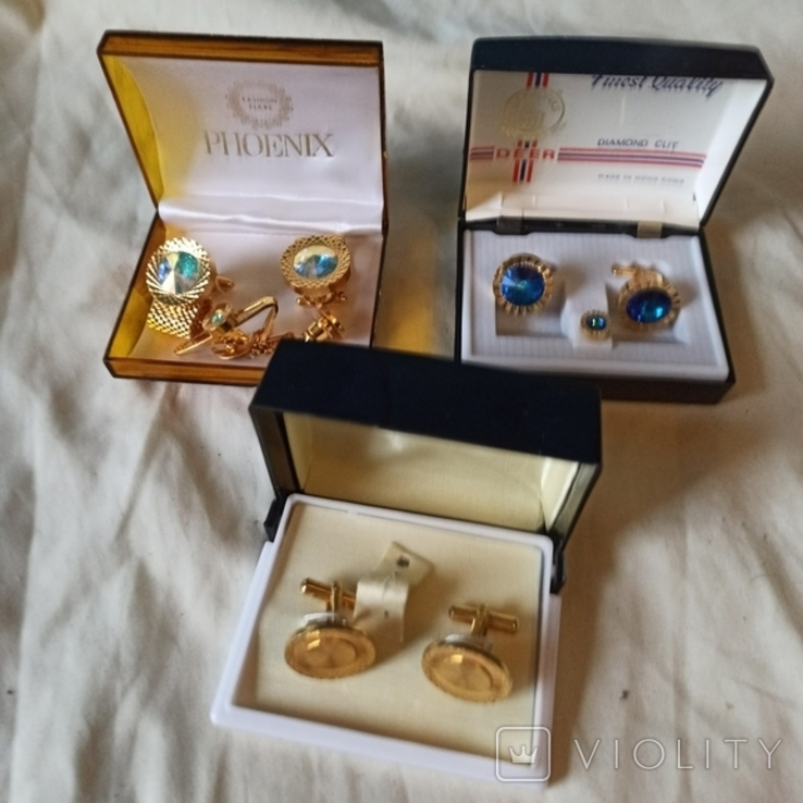 Three sets of branded cufflinks.