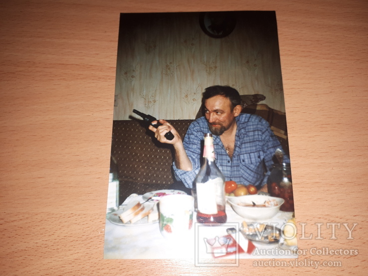 Фото мужчина сидит за столом с пистолетом в руке