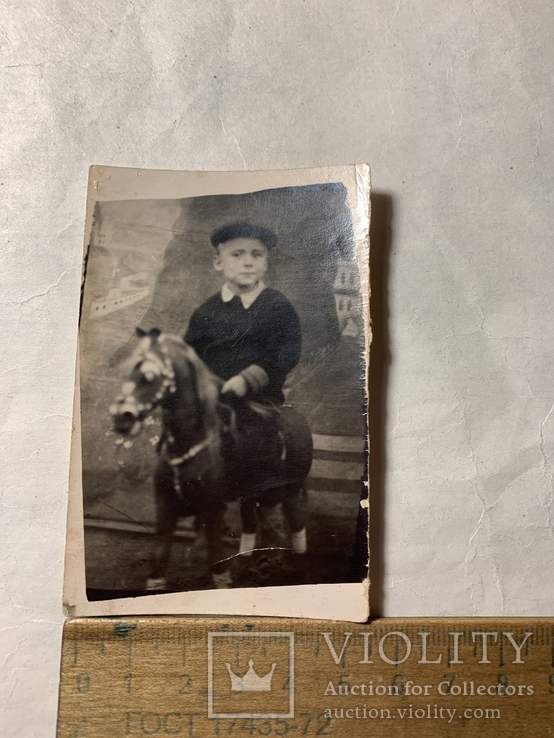 Мальчик в кепи на макетирований лошади