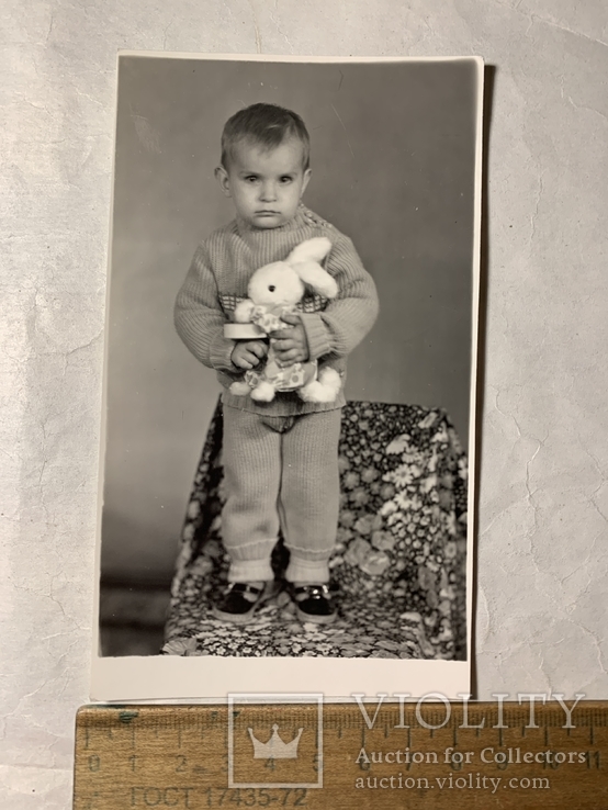 Ребёнок на стуле в руках игрушкой, фото №2