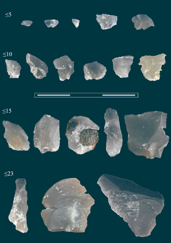 Flint chips are sorted by size in millimeters. Scale - 3 cm.