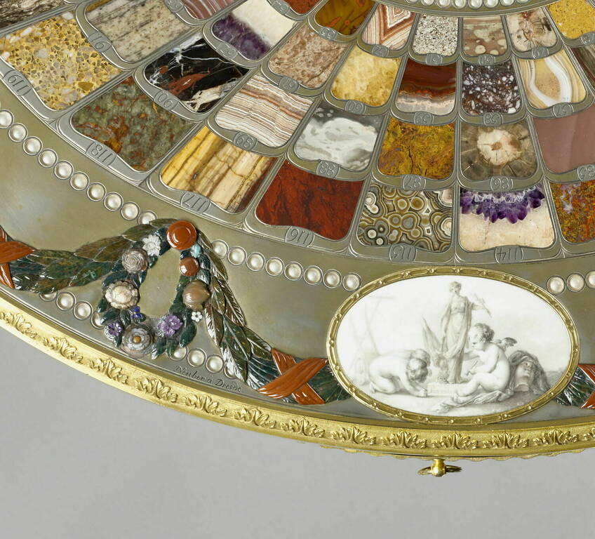 Столик Тешена зі 128 зразками напівкоштовних і виробних каменів. Овальна стільниця прикрашена медальйонами із саксонської порцеляни з алегоріями миру. Висота 81,5 см. Йоганн Крістіан Нойбер, Дрезден, 1780 рік