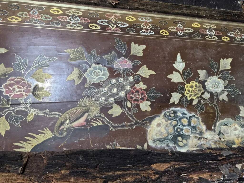 Дерев'яний саркофаг, прикрашений малюнками квітів і павичів