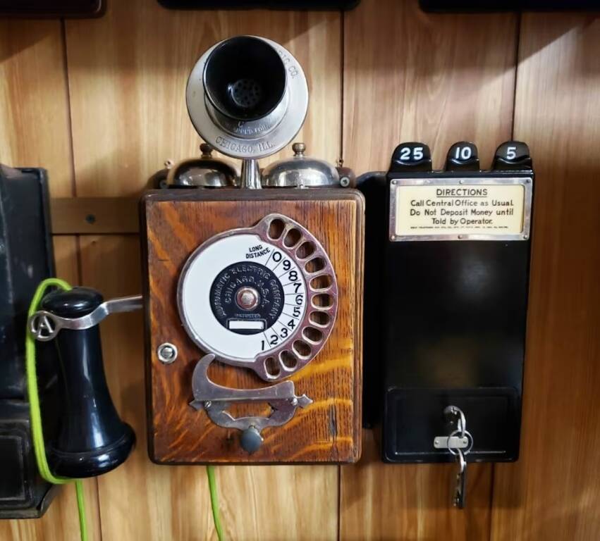 Телефон 1905 року Strowger/Automatic Electric з 11-значним номеронабирачем «кастет». Розташований на дощечці поруч із платіжним апаратом 1909 року