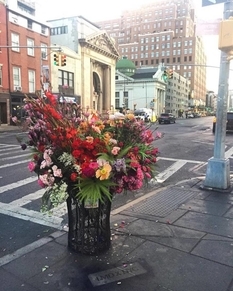 Florist artist and his team decorate garbage cans with flowers left after weddings